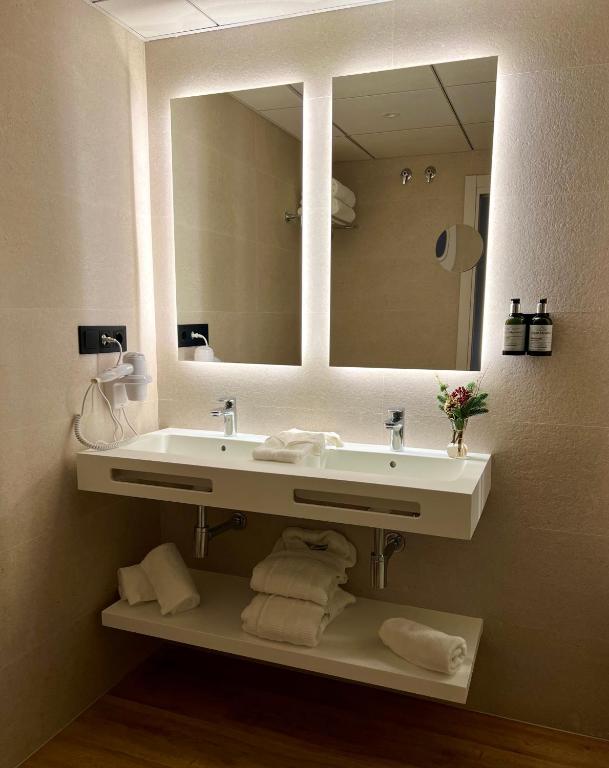 a bathroom with a sink and a large mirror at Óbal Hotel Marbella in Marbella
