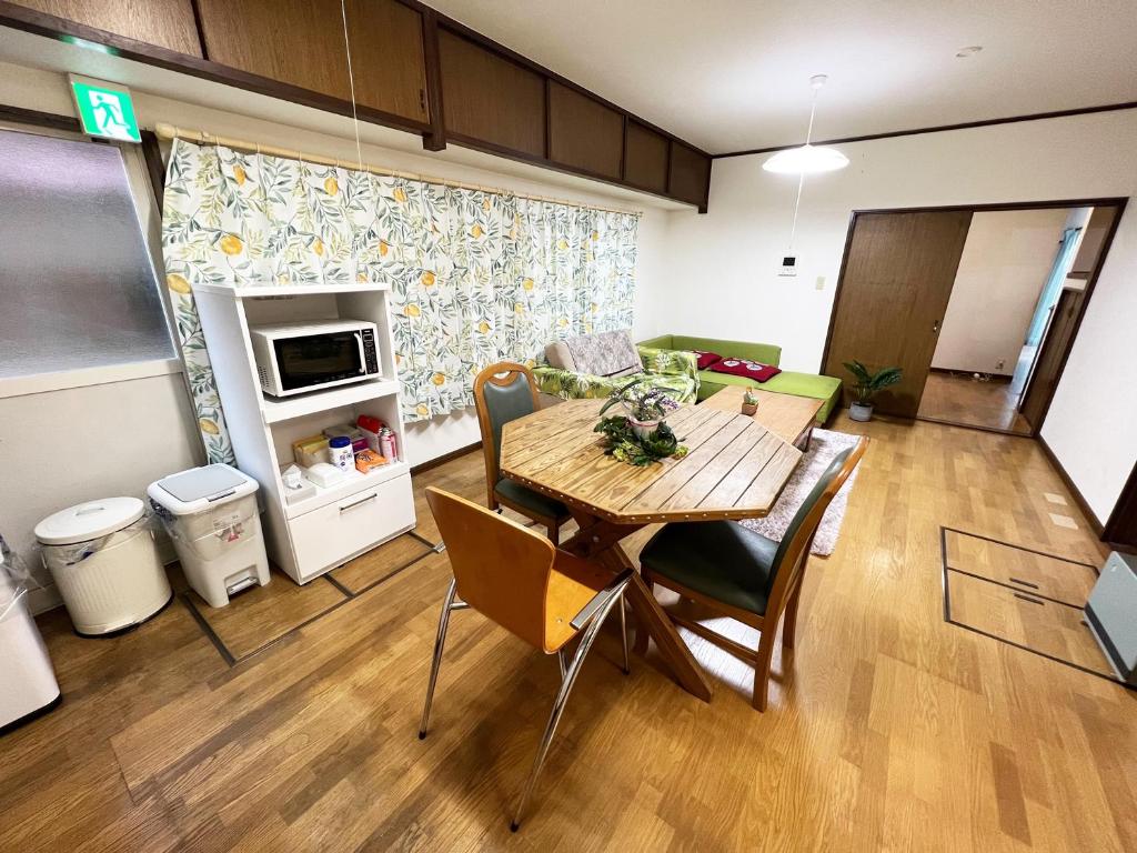 uma cozinha e sala de jantar com mesa e cadeiras em 別府ホーム em Beppu