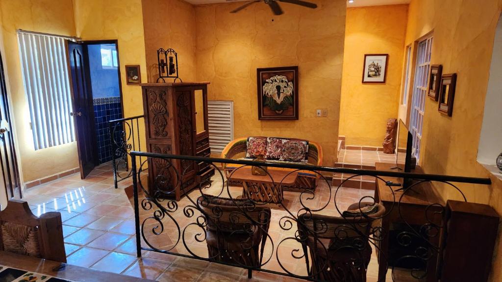 a room with a balcony with a table and chairs at Casa Colonial, Cozumel in Cozumel