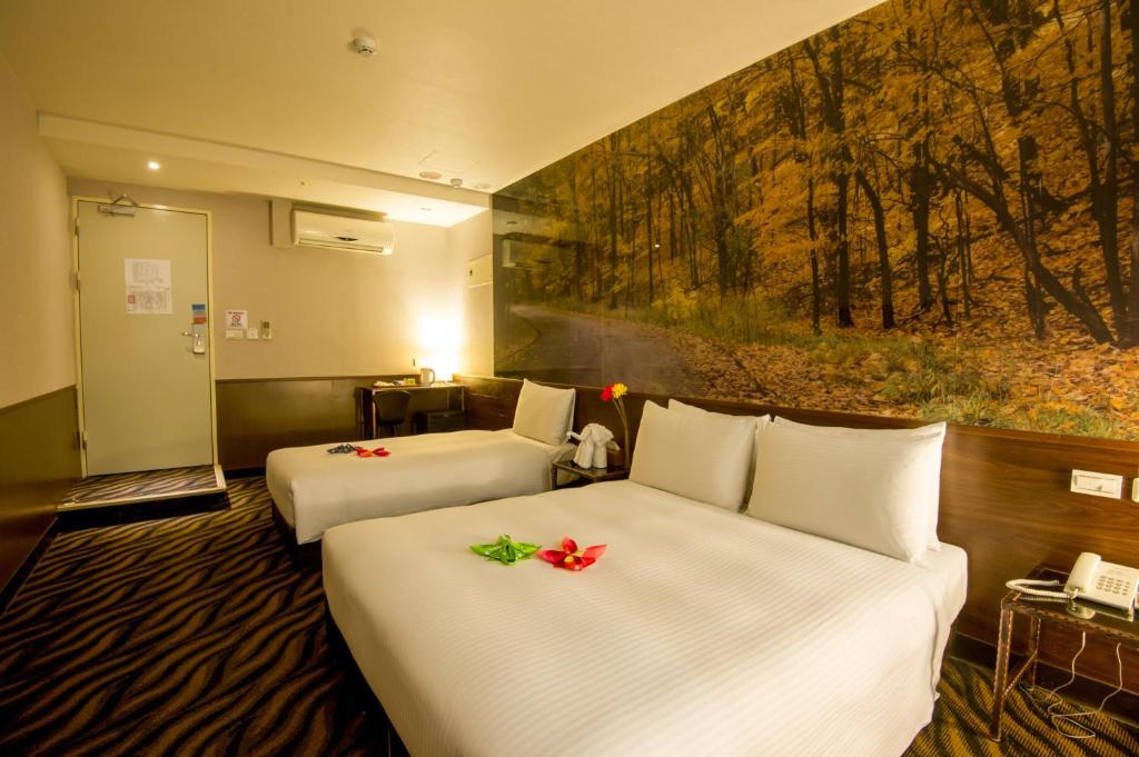 a hotel room with two beds and a painting on the wall at Hotel 6 - Wannien in Taipei