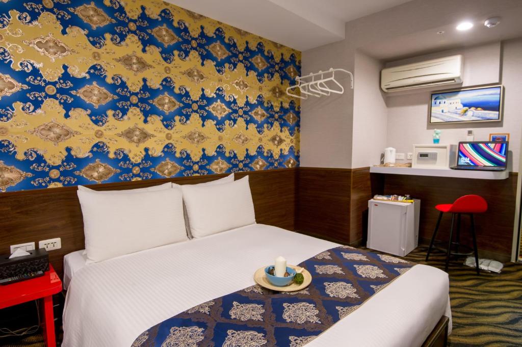 a bedroom with a bed and a blue and yellow wall at Hotel 6 - Wannien in Taipei