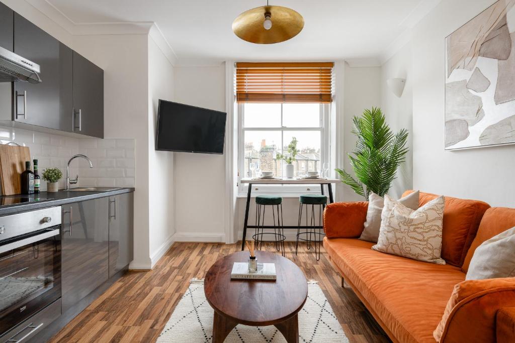 een woonkamer met een bank en een tafel bij Urban Rest Notting Hill Apartments in Londen