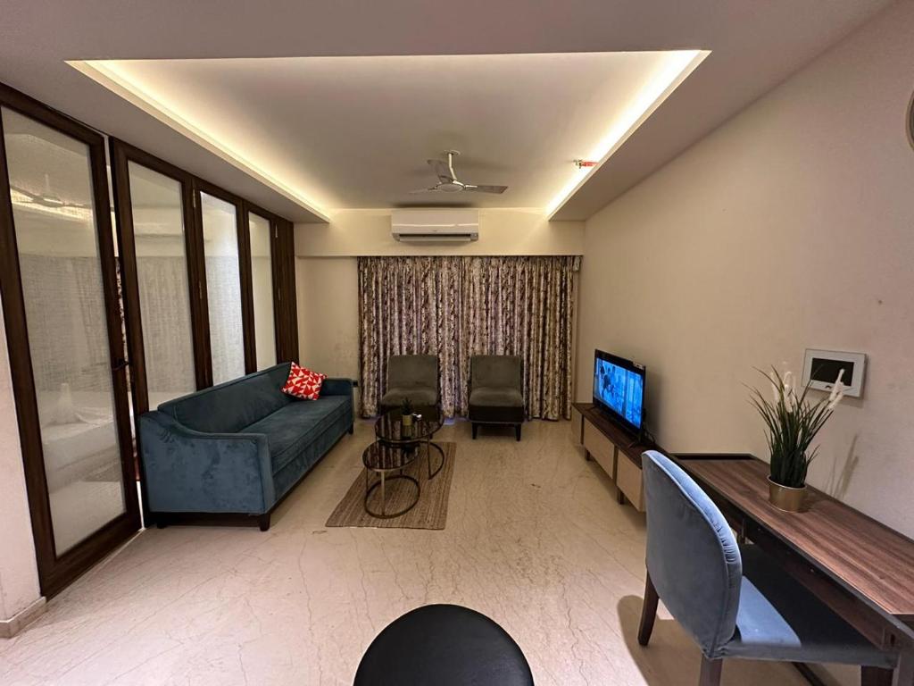 a living room with a couch and a tv at 1.5BR Service apartment in BKC by Florastays in Mumbai