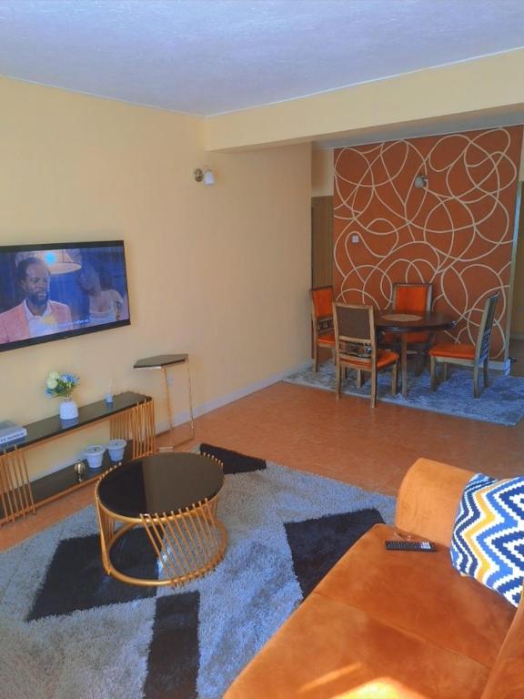 a living room with a couch and a tv at Elite homes in Kisumu