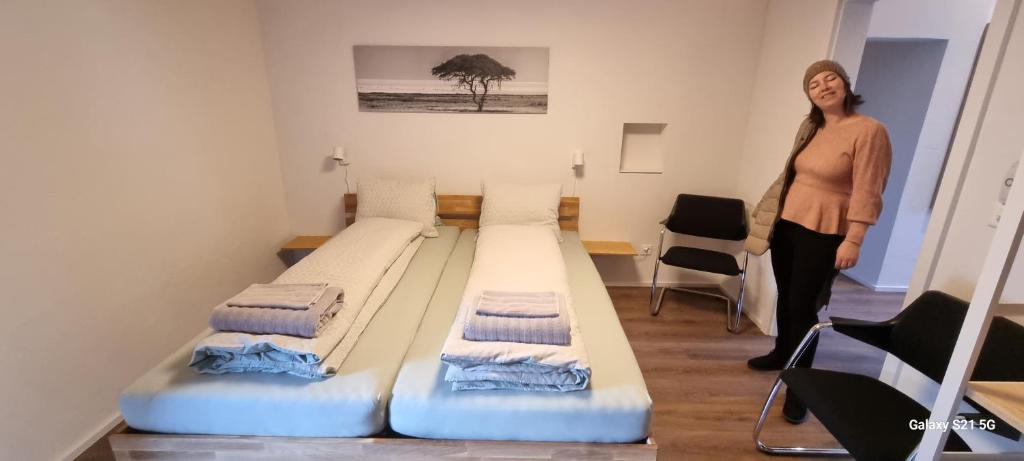 uma mulher num quarto com duas camas em Mountain - Lake Apartement 1 em Wilderswil
