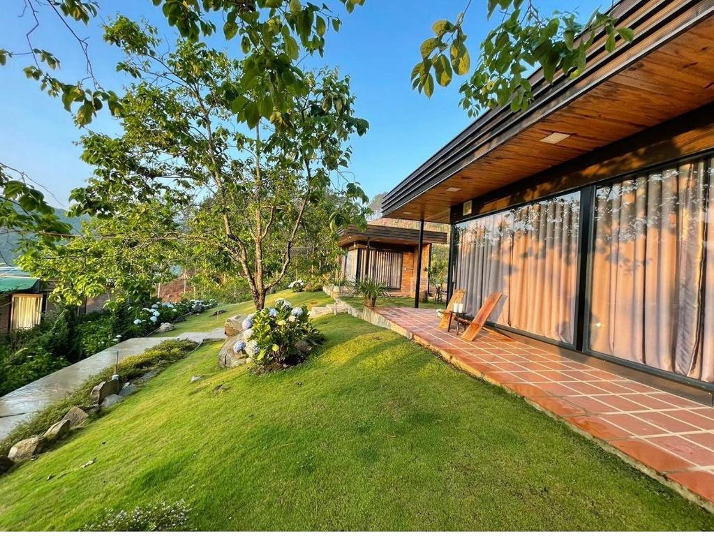uma casa com um pátio de tijolos e um quintal relvado em Scent Bungalow - Village em Da Lat