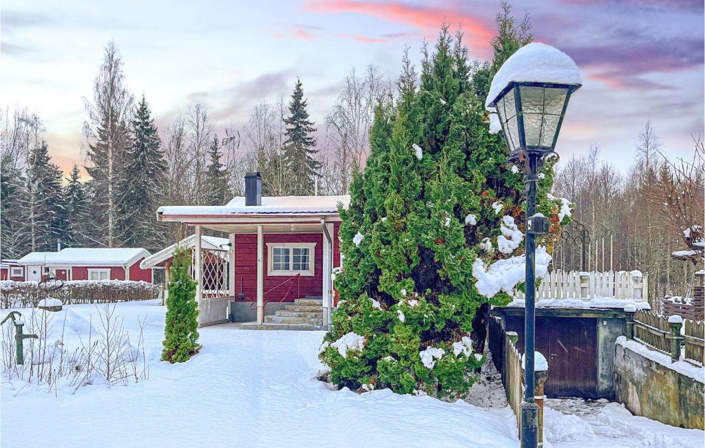 ein Haus mit einem Weihnachtsbaum im Schnee in der Unterkunft Stunning Home In Katrineholm With Wi-fi in Katrineholm
