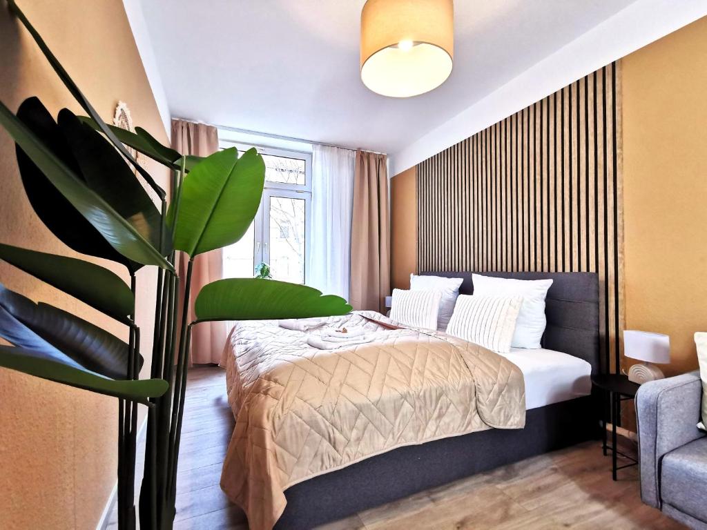 um quarto com uma cama e um vaso de plantas em BohnApartments Junior SUITE Blume 14 - Nähe Dom - WLAN em Erfurt