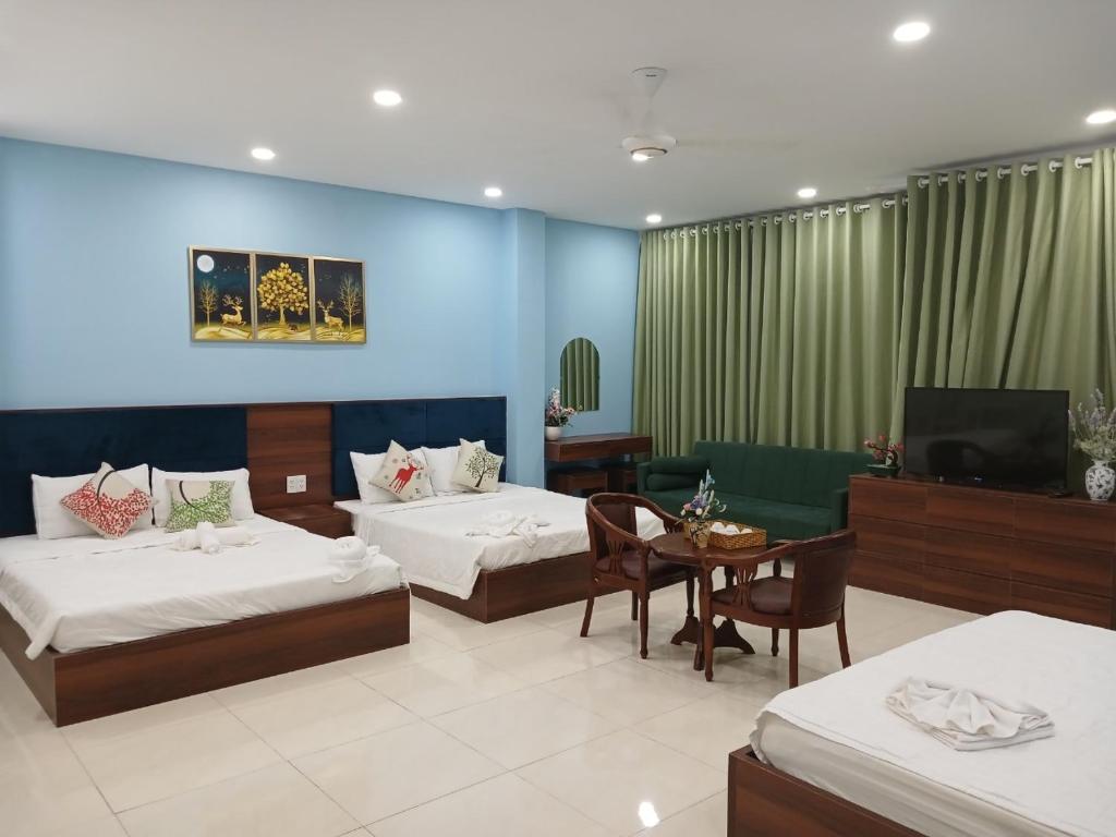a hotel room with two beds and a television at Hà Nội Quán Homstay in Phu Quoc