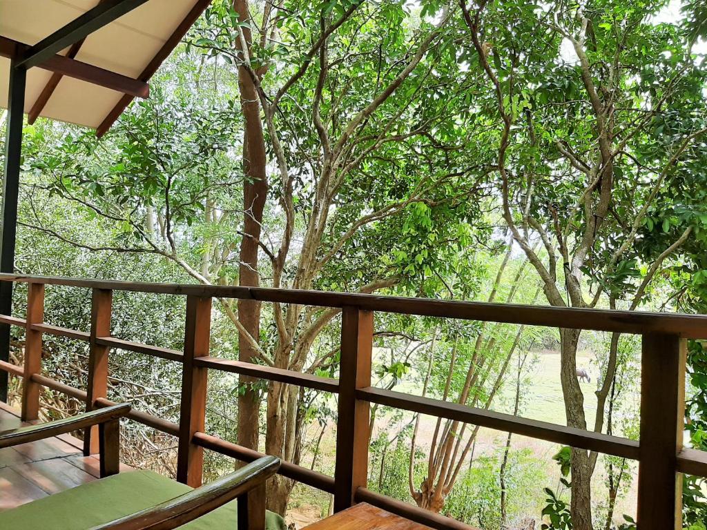 a balcony with a view of a forest at Elephant Lodge in Udawalawe
