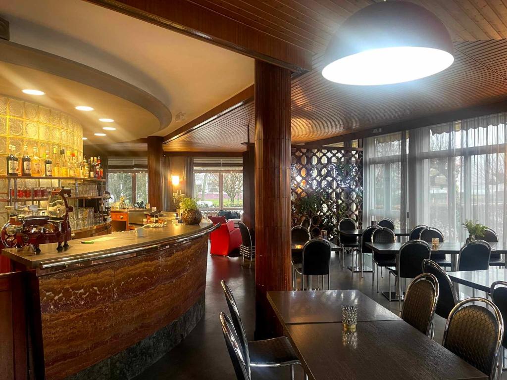 un restaurant avec un bar doté de tables et de chaises dans l'établissement Hôtel La Réserve, à Gérardmer
