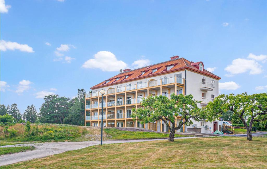 a large white building with a red roof at Stunning Apartment In Stjrnhov With House Sea View in Stjärnhov