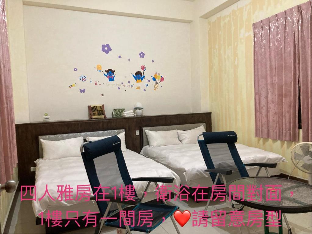 a bedroom with two beds and a table and two chairs at Guanshan Fukuda Homestay in Guanshan