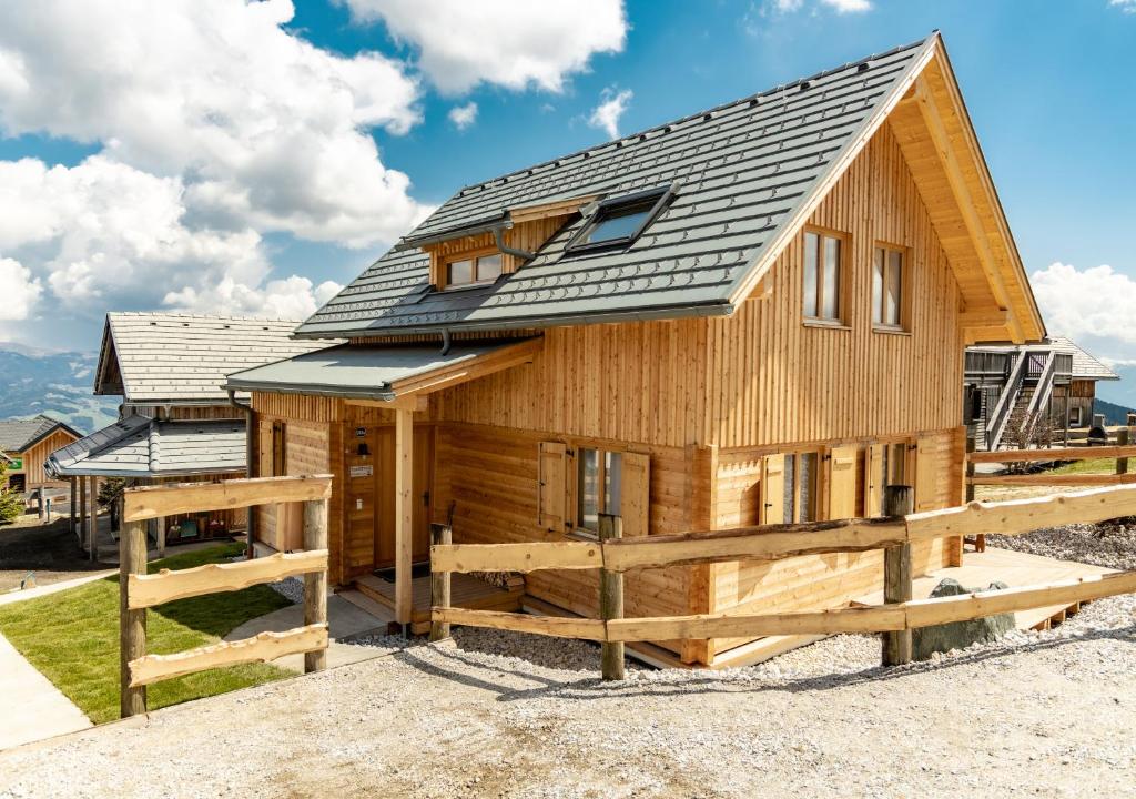 Cabaña de madera con techo de metal y valla de madera en 1A Chalet 'Horst' Wandern und Grillen, Panorama Sauna! en Klippitztorl