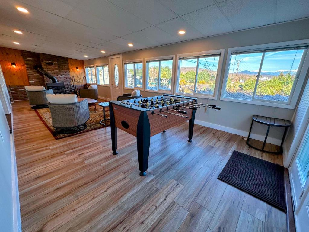 a room with a foosball table in the middle of a room at Renovated farmhouse on snowmobile trail with firepit & mountain views, 10 min from Bretton Woods! in Twin Mountain