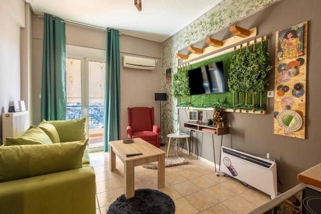 a living room with a green couch and a table at GPX-CLR TheGreenFamilySuite in Larisa