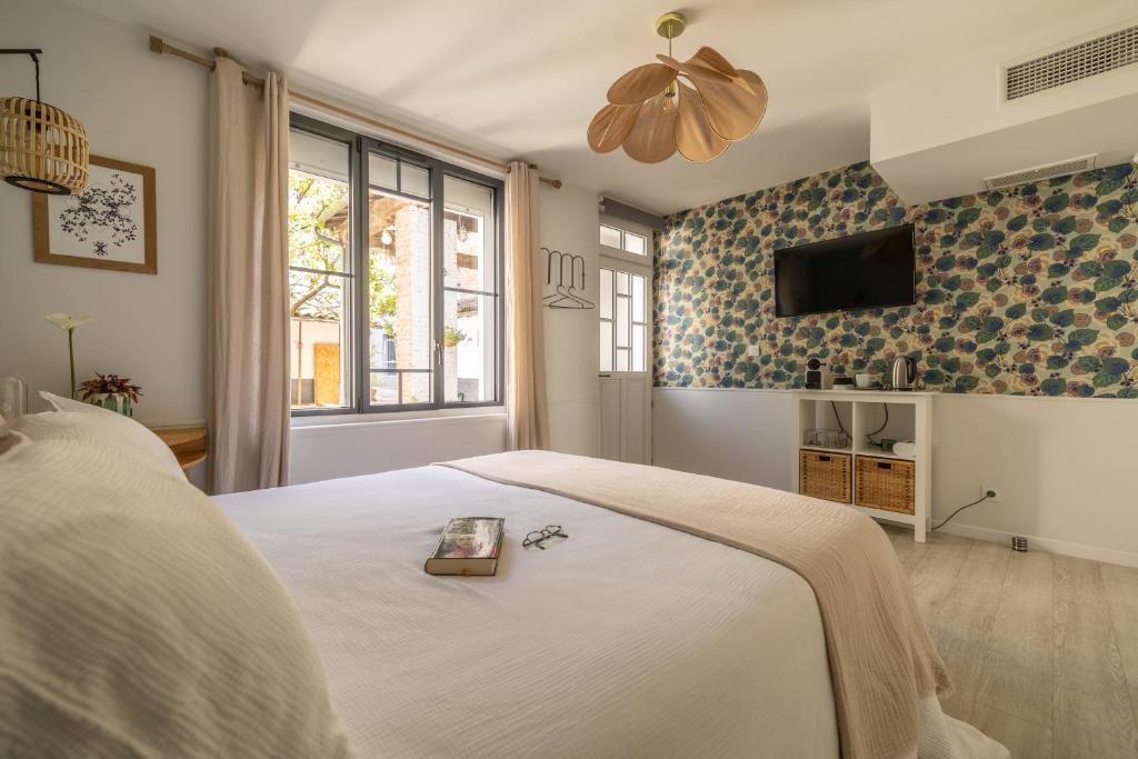 sypialnia z łóżkiem i telewizorem na ścianie w obiekcie B&B La Maison de Julia w mieście Albi