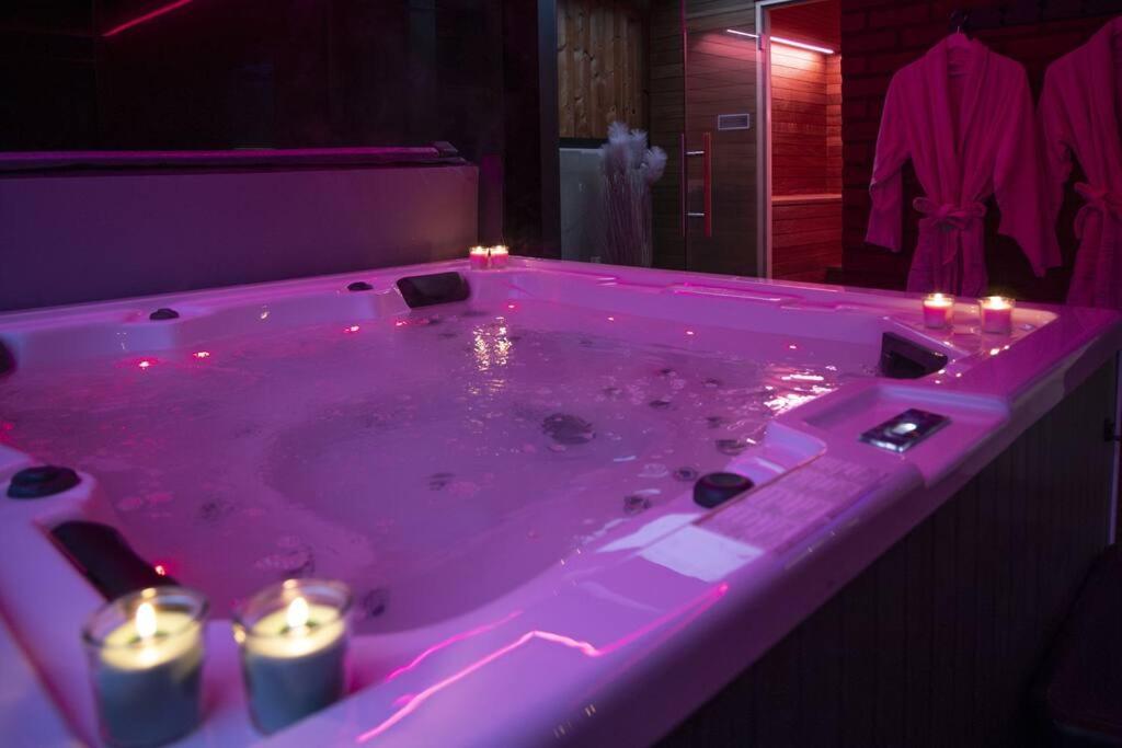 a pink bath tub with candles in a bathroom at SuiteDreams - Bali Suite Liège in Liège