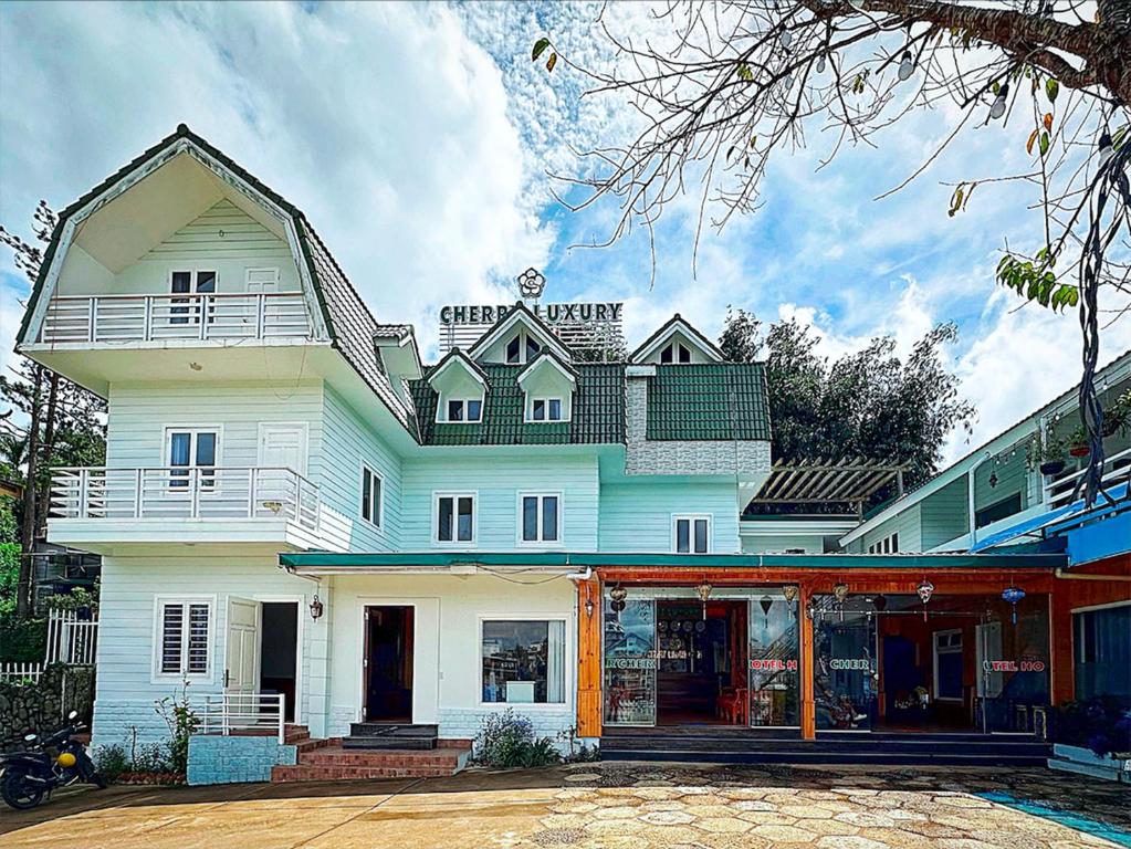 a large white building with a store in front of it at The Cherry Hill Hotel in Xuan An