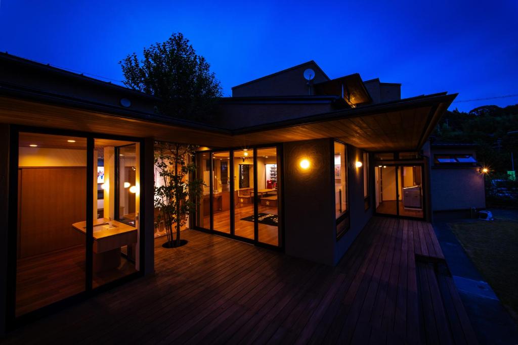 a house with a deck at night at 隠れ家アートヴィラ Villa Revolla in Makinohara