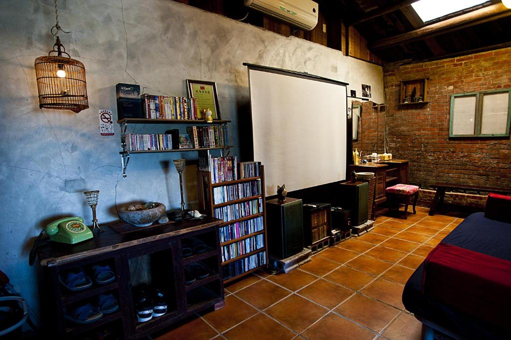 a living room with a book shelf and a white board at Shabby Home 28 in Jiufen