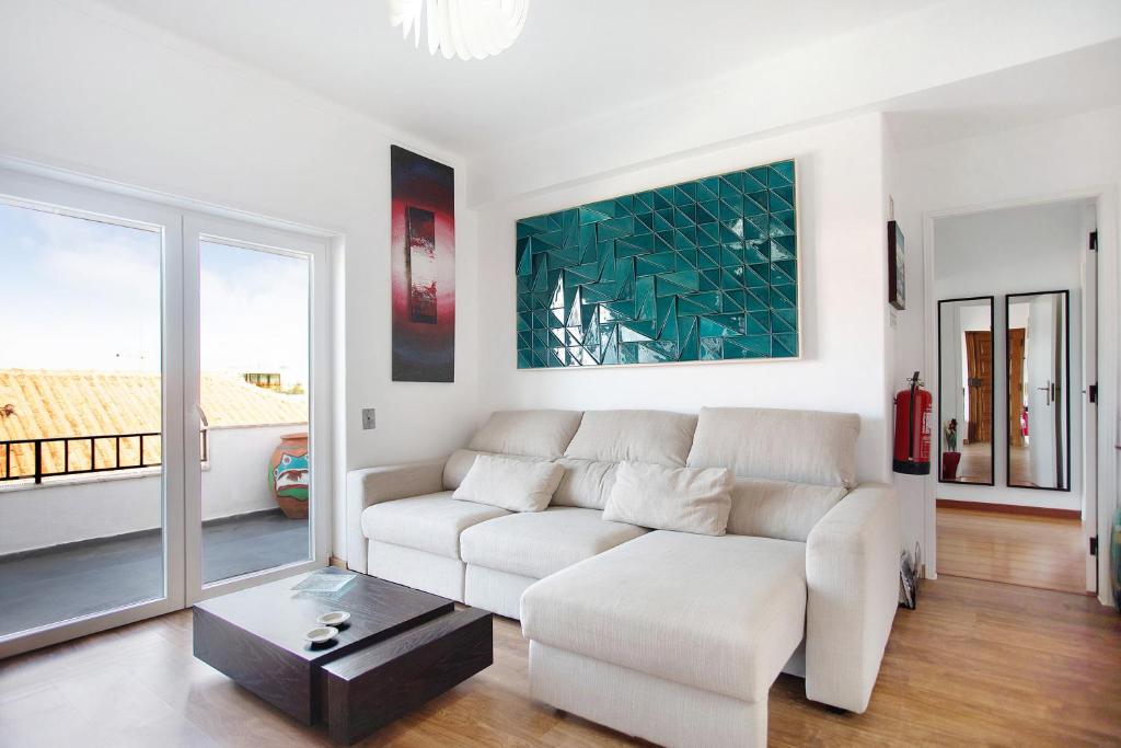 a white living room with a couch and a table at Apartamento da Alegria in Caldas da Rainha