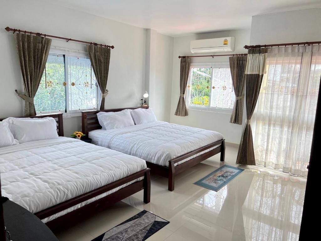 a bedroom with two beds and two windows at BAAN OZONE HY2 in Hat Yai