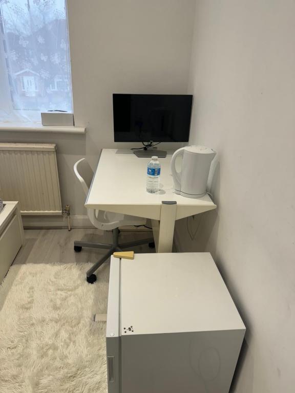 an office with a white desk and a computer monitor at Single Room in Canvey