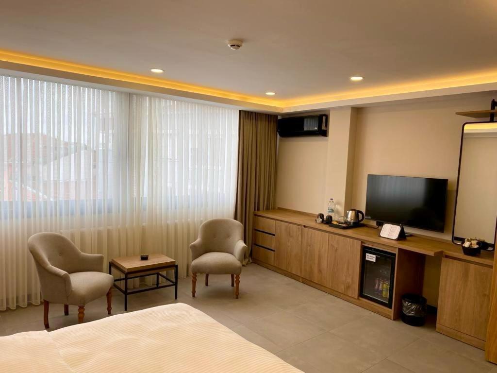 um quarto de hotel com uma cama e uma televisão de ecrã plano em BeL LETTO HOTEL em Istambul