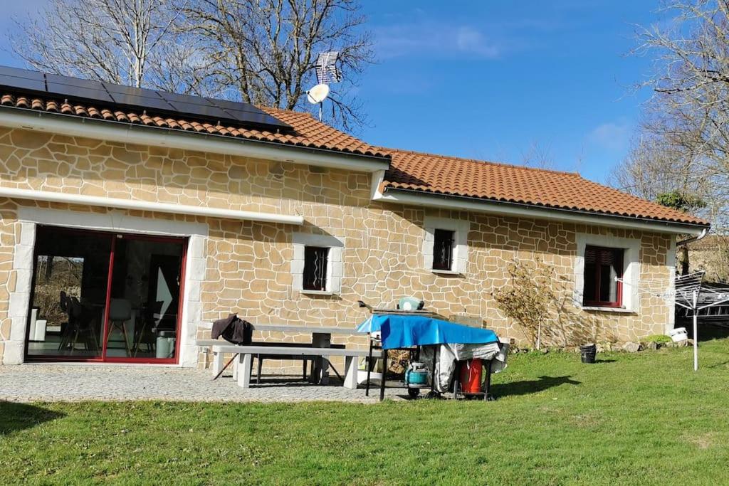 una casa de piedra con una mesa de picnic delante de ella en Villa avec tout le confort dans le livradois forez 