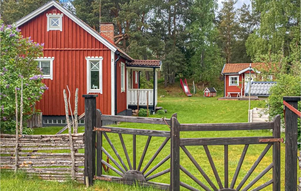 une grange rouge avec un portail en face d'une maison dans l'établissement Beautiful Home In Trans With Kitchen, à Tranås