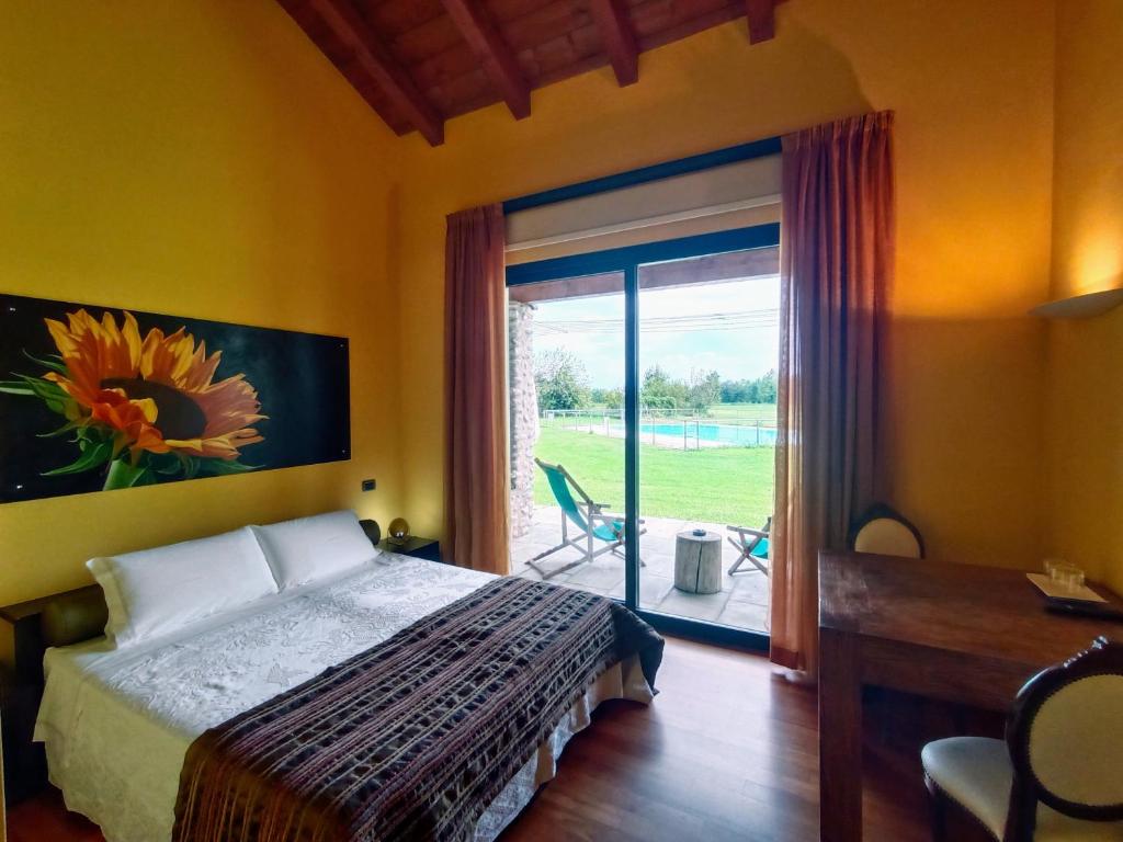a bedroom with a bed and a sliding glass door at Agriturismo Corte Carnevale in Marmirolo