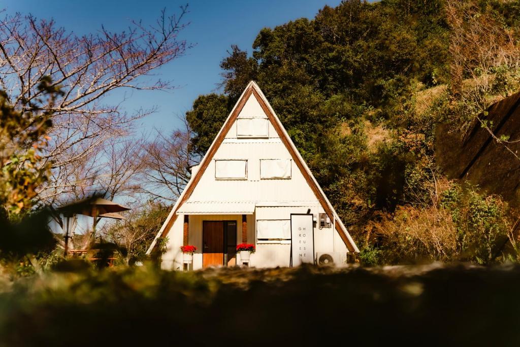 a small white house with a pointed roof at GREEN HOUSE -非対面ﾁｪｯｸｲﾝContactless Bed & Breakfast - in Shimanto