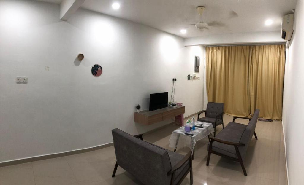 a living room with chairs and a table and a television at 4 Bedrooms Semi D Muslim Homestay by Mr Homestay Kulim in Kulim