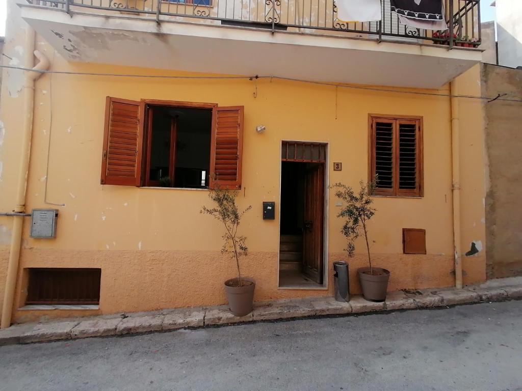 un edificio con due piante in vaso sul lato di Stanza con terrazza a Calamonaci