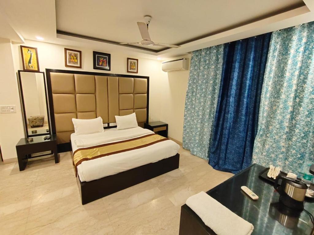 a hotel room with a bed and a desk at GK Residency Kailash Colony in New Delhi