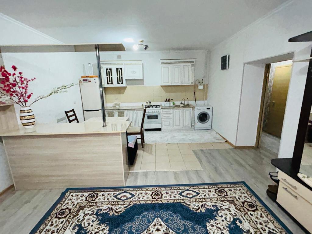 eine große Küche mit einem Kühlschrank und einem Tisch in der Unterkunft Квартира в центре города,в ЖК Куралай in Qysylorda