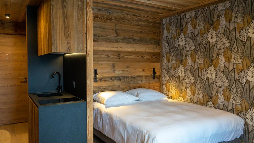 a bedroom with a bed in a room with wooden walls at RESIDENCE GRAND COCOR -Studio 25 m2- in Val-d'Isère