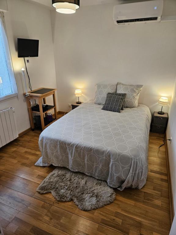 sypialnia z łóżkiem z szarą kołdrą i 2 lampami w obiekcie Chambre d'hôte Lempautoise Internet par fibre w mieście Lempaut