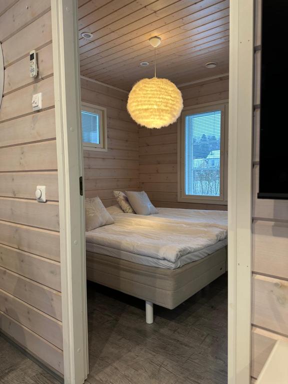 um quarto com uma cama num quarto com um lustre em Villa Lilla em Porvoo