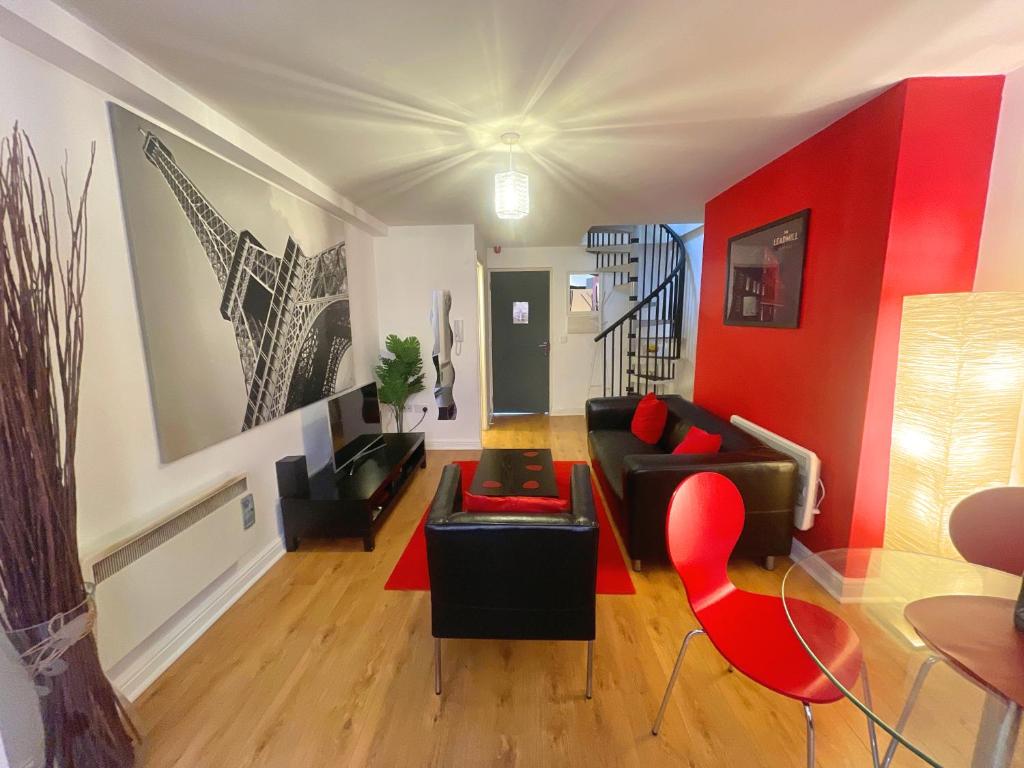 a living room with a black couch and red walls at Vibrant Loft Apartment in Grade II Listed Georgian Building in Sheffield
