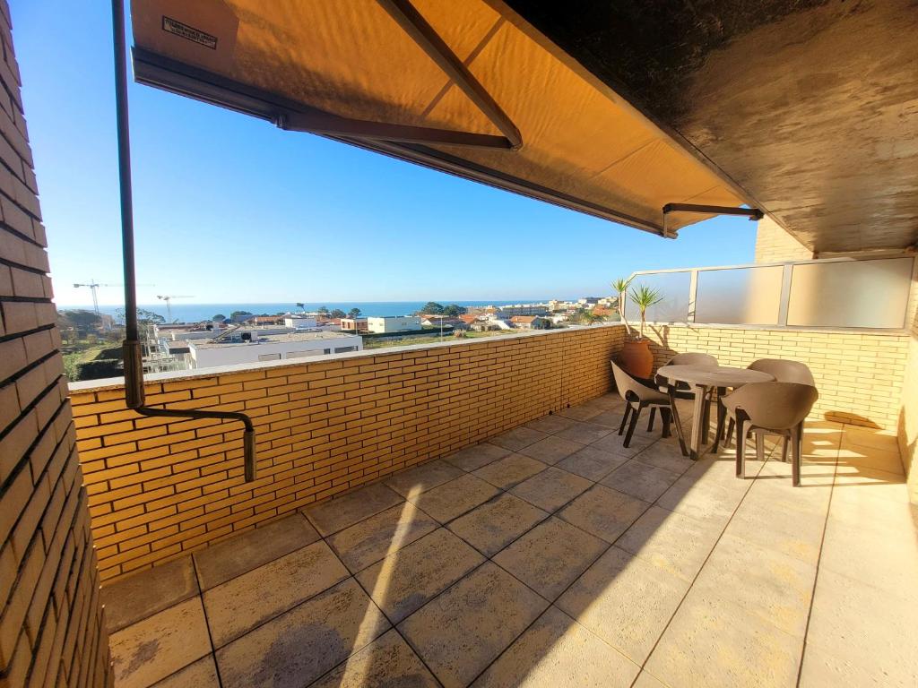 eine Terrasse mit einem Tisch und Stühlen an einer Ziegelwand in der Unterkunft Casa da Praia in Vila Nova de Gaia