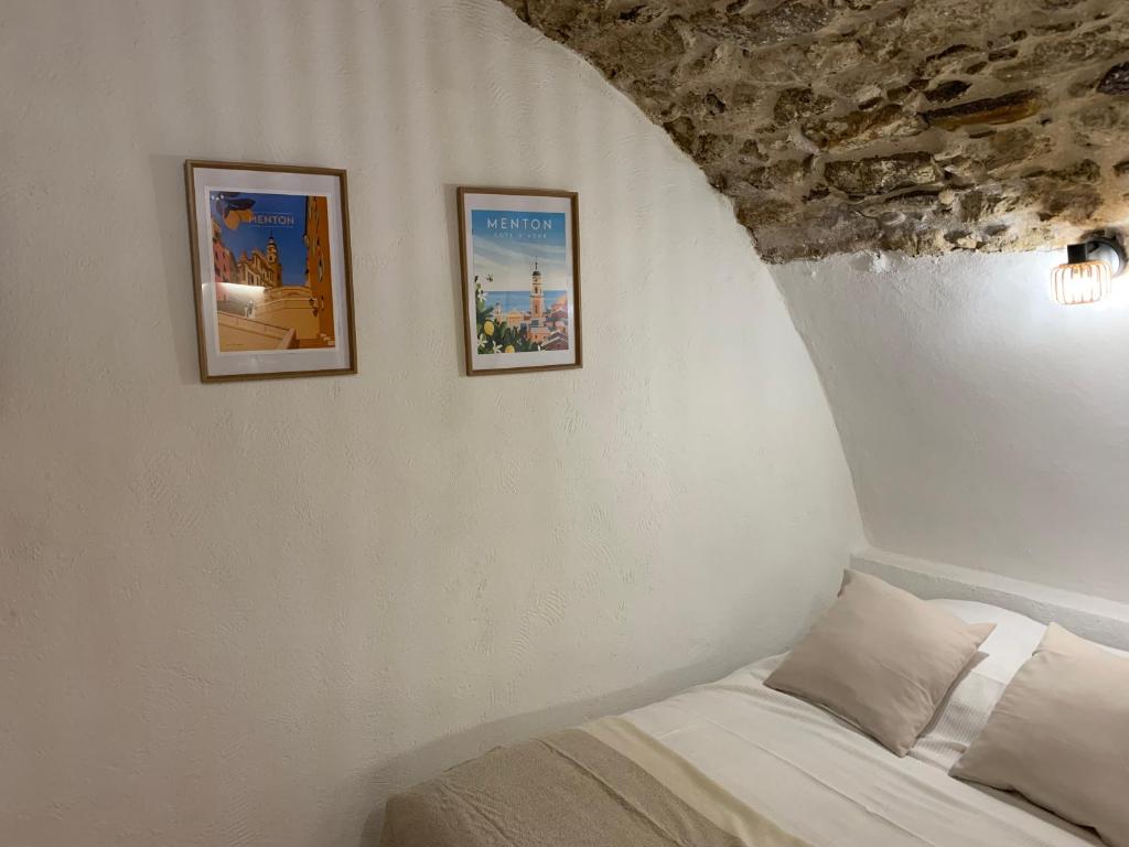 a bedroom with two pictures on the wall and a bed at Studio Perle de Menton in Menton