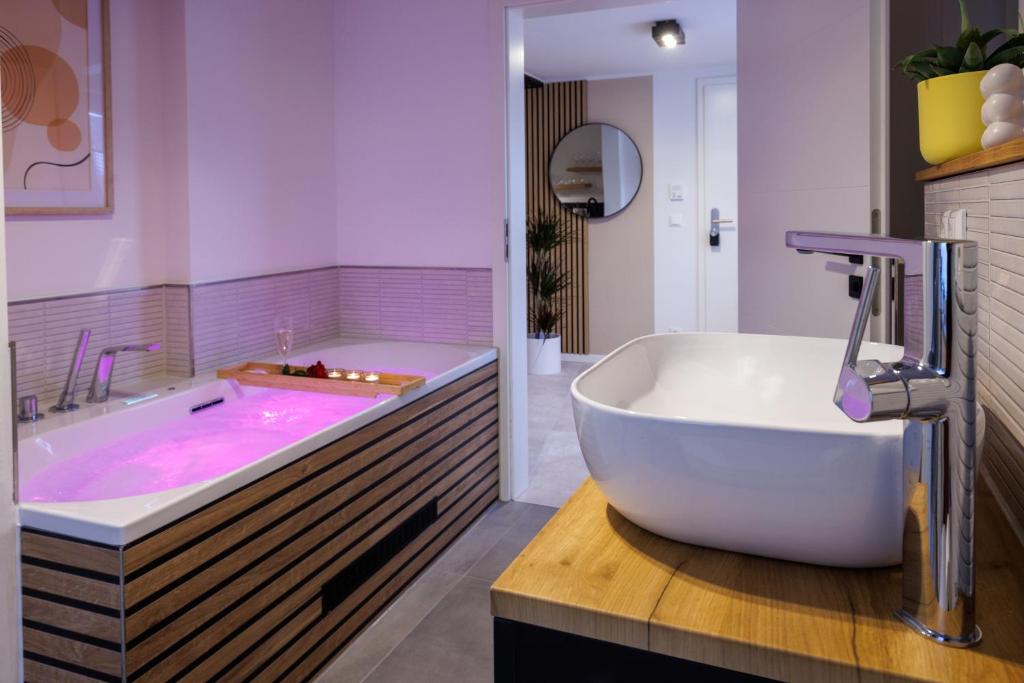 La salle de bains est pourvue d'une grande baignoire rose. dans l'établissement Romantisches Apartment mit Whirlpool in Bayreuther Fußgängerzone, à Bayreuth
