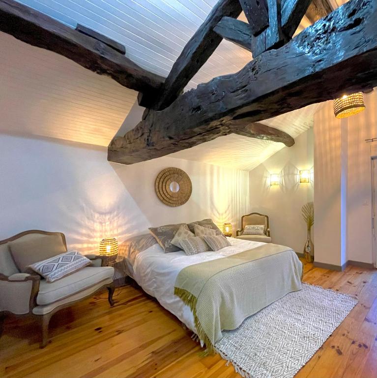 une chambre avec un lit et une chaise dedans dans l'établissement Maison au coeur de la Dombes, à Le Plantay