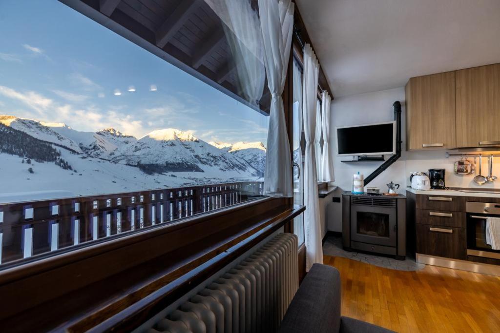 a kitchen with a balcony with a view of snow covered mountains at Appartamento Lorenzo in Livigno