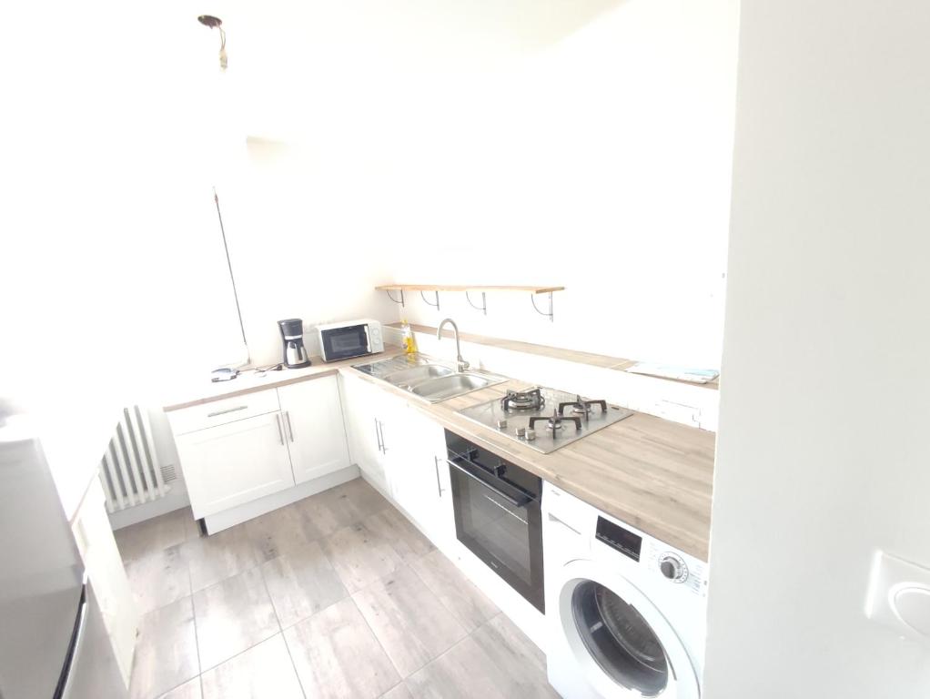 a white kitchen with a sink and a dishwasher at Logement entier : appartement - Brest in Brest