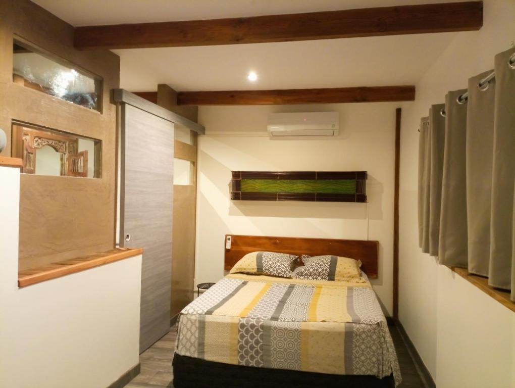 1 dormitorio con 1 cama en una habitación en Le ti bali Chambre, en Saint-Leu