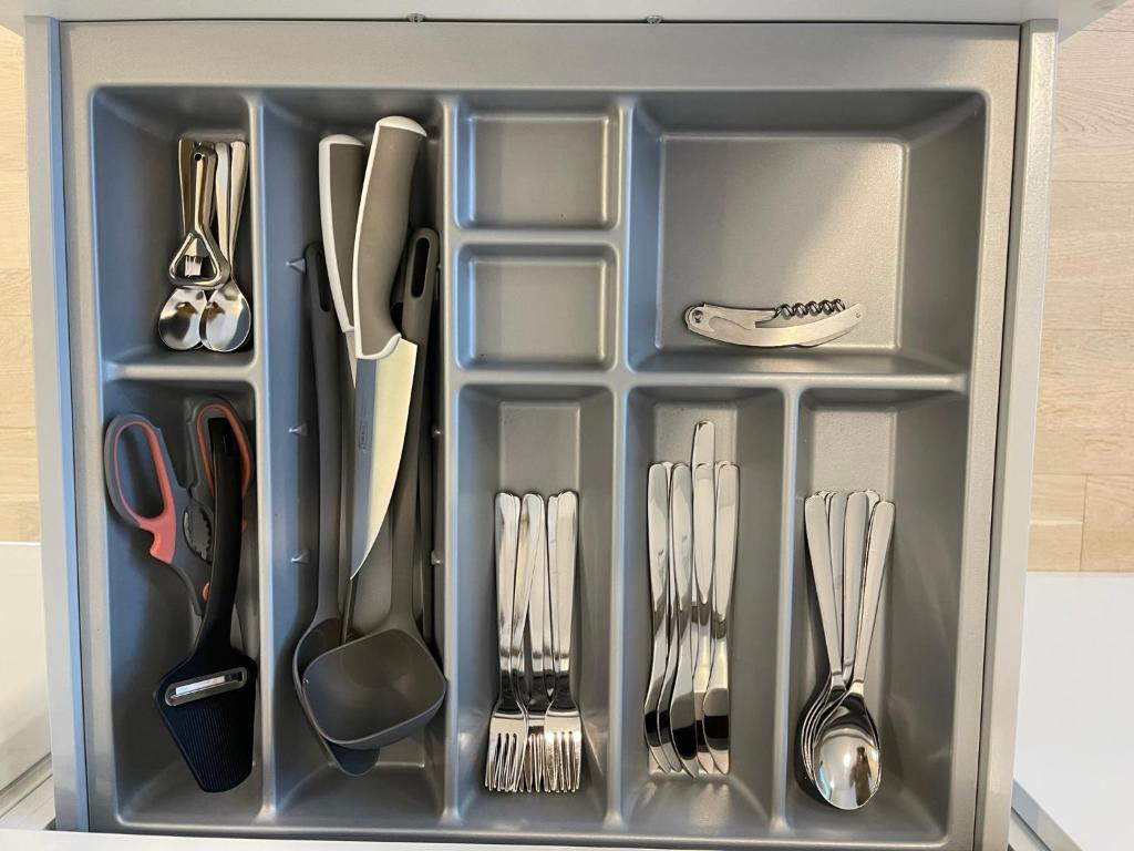 a utensil drawer with utensils in it at Lovely apartment next to the train station in Vantaa