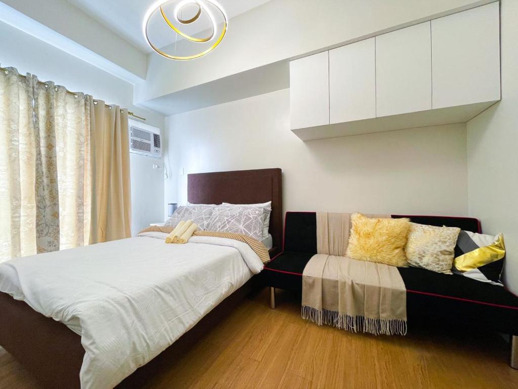 a bedroom with a bed and a couch at The Loop North Tower in Cagayan de Oro